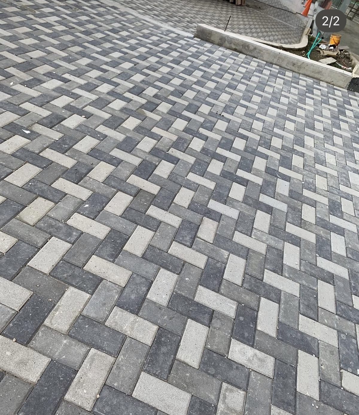 Via urbana pavimentada con adoquines de concreto en patron espiga bicolor