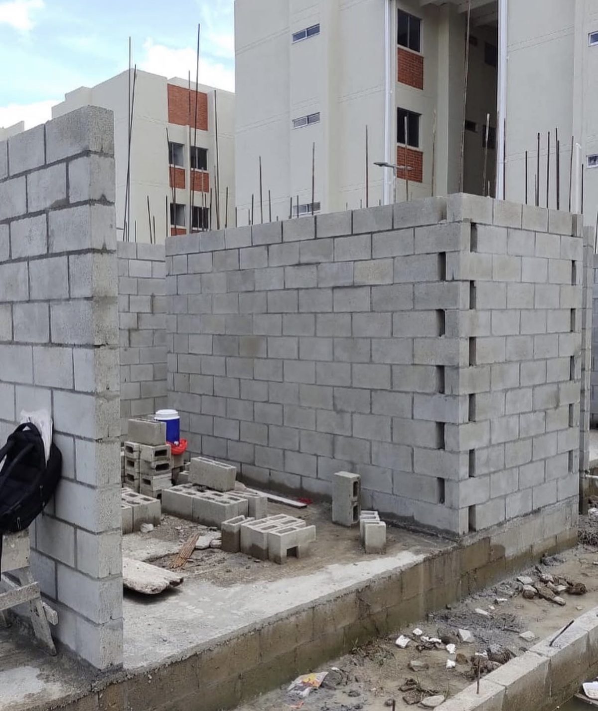 Muro de bloque de concreto en obra, con unidades apiladas en primer plano